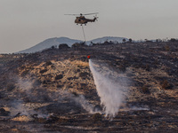 A helicopter is operating during a fire in Limassol, Cyprus, on May 9, 2024. The wildfire, which broke out in the Industrial Zone of Ipsonas...