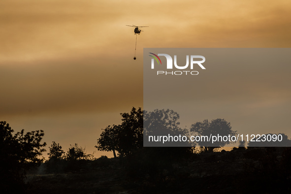 A helicopter is operating during a fire in Limassol, Cyprus, on May 9, 2024. The wildfire, which broke out in the Industrial Zone of Ipsonas...