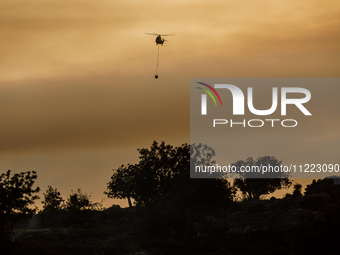 A helicopter is operating during a fire in Limassol, Cyprus, on May 9, 2024. The wildfire, which broke out in the Industrial Zone of Ipsonas...