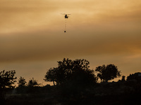 A helicopter is operating during a fire in Limassol, Cyprus, on May 9, 2024. The wildfire, which broke out in the Industrial Zone of Ipsonas...