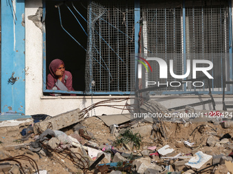 A displaced Palestinian woman is looking out of a school window after returning to Khan Yunis in the southern Gaza Strip, on May 9, 2024, am...