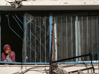 A displaced Palestinian woman is looking out of a school window after returning to Khan Yunis in the southern Gaza Strip, on May 9, 2024, am...