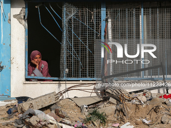 A displaced Palestinian woman is looking out of a school window after returning to Khan Yunis in the southern Gaza Strip, on May 9, 2024, am...