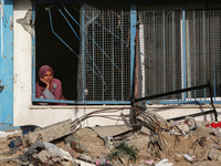 A displaced Palestinian woman is looking out of a school window after returning to Khan Yunis in the southern Gaza Strip, on May 9, 2024, am...