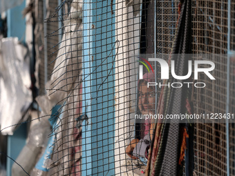 A displaced Palestinian woman is looking out of a school window after returning to Khan Yunis in the southern Gaza Strip, on May 9, 2024, am...