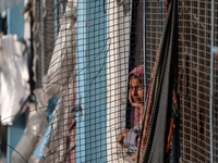 A displaced Palestinian woman is looking out of a school window after returning to Khan Yunis in the southern Gaza Strip, on May 9, 2024, am...