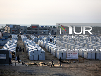 People are walking into a newly-built tent at a camp for displaced Palestinians in Khan Yunis, in the southern Gaza Strip, on May 9, 2024, a...