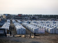 People are walking into a newly-built tent at a camp for displaced Palestinians in Khan Yunis, in the southern Gaza Strip, on May 9, 2024, a...