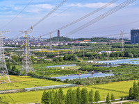 Construction workers are installing spacer rods at a high altitude at the site of a 500-kilovolt line renovation project in Wuxi, Jiangsu Pr...