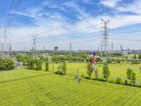 Construction workers are installing spacer rods at a high altitude at the site of a 500-kilovolt line renovation project in Wuxi, Jiangsu Pr...