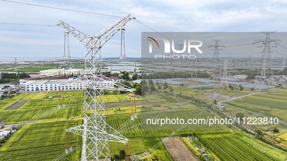 Construction workers are installing spacer rods at a high altitude at the site of a 500-kilovolt line renovation project in Wuxi, Jiangsu Pr...