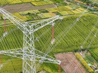 Construction workers are installing spacer rods at a high altitude at the site of a 500-kilovolt line renovation project in Wuxi, Jiangsu Pr...