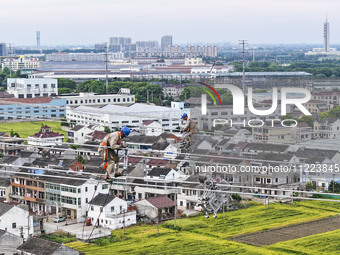 Construction workers are installing spacer rods at a high altitude at the site of a 500-kilovolt line renovation project in Wuxi, Jiangsu Pr...