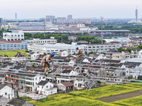 Construction workers are installing spacer rods at a high altitude at the site of a 500-kilovolt line renovation project in Wuxi, Jiangsu Pr...