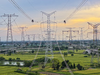 Construction workers are installing spacer rods at a high altitude at the site of a 500-kilovolt line renovation project in Wuxi, Jiangsu Pr...