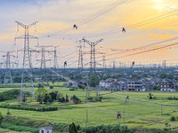 Construction workers are installing spacer rods at a high altitude at the site of a 500-kilovolt line renovation project in Wuxi, Jiangsu Pr...