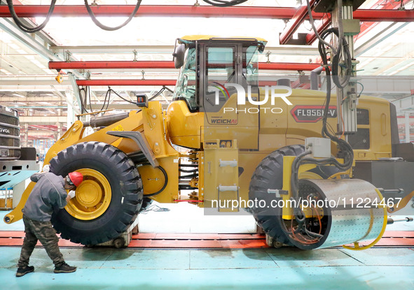 Workers are producing loaders on a production line at LOVOL Co in Qingdao, Shandong Province, China, on May 9, 2024. 