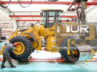 Workers are producing loaders on a production line at LOVOL Co in Qingdao, Shandong Province, China, on May 9, 2024. (