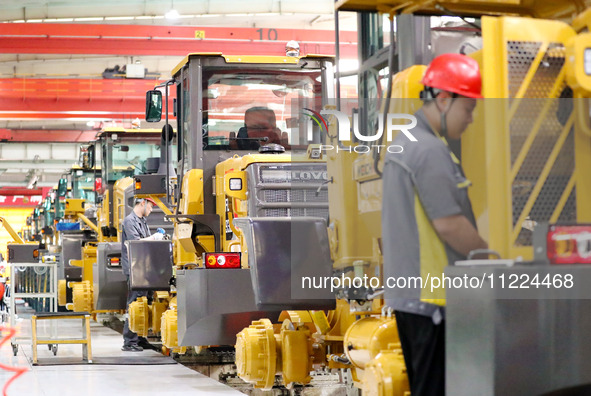 Workers are producing loaders on a production line at LOVOL Co in Qingdao, Shandong Province, China, on May 9, 2024. 