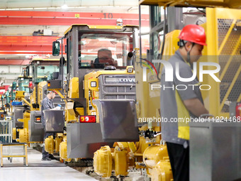 Workers are producing loaders on a production line at LOVOL Co in Qingdao, Shandong Province, China, on May 9, 2024. (