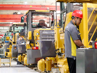 Workers are producing loaders on a production line at LOVOL Co in Qingdao, Shandong Province, China, on May 9, 2024. (