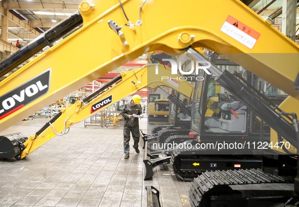 A worker is looking at a production schedule on a production line of LOVOL Co in Qingdao, Shandong Province, China, on May 9, 2024. 