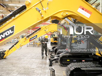 A worker is looking at a production schedule on a production line of LOVOL Co in Qingdao, Shandong Province, China, on May 9, 2024. (