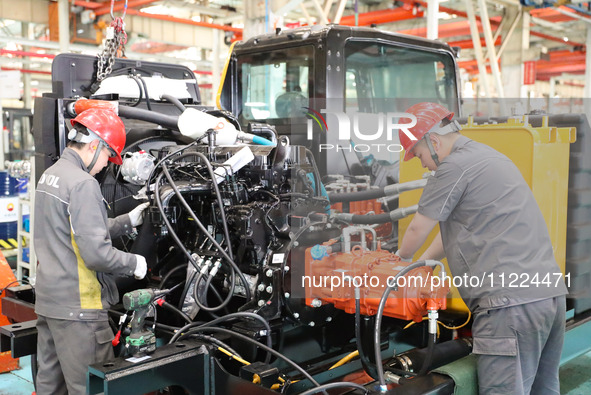 Workers are producing loaders on a production line at LOVOL Co in Qingdao, Shandong Province, China, on May 9, 2024. 