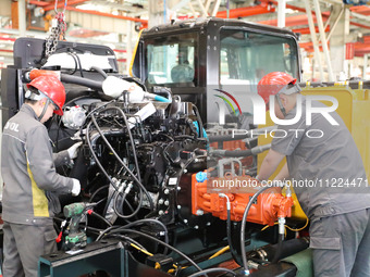 Workers are producing loaders on a production line at LOVOL Co in Qingdao, Shandong Province, China, on May 9, 2024. (