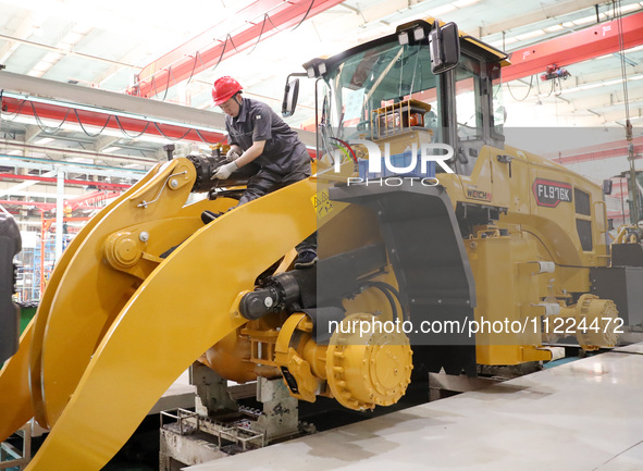 Workers are producing loaders on a production line at LOVOL Co in Qingdao, Shandong Province, China, on May 9, 2024. 