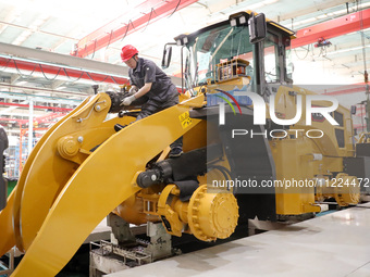 Workers are producing loaders on a production line at LOVOL Co in Qingdao, Shandong Province, China, on May 9, 2024. (