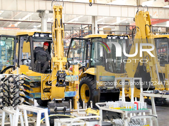 Workers are debugging an excavator on the production line of LOVOL Co in Qingdao, Shandong Province, China, on May 9, 2024. (