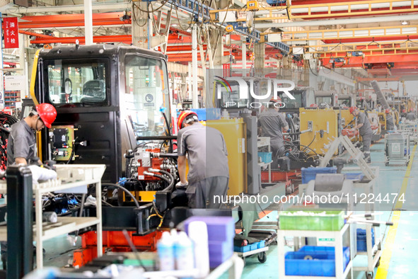 Workers are operating excavators on a production line at LOVOL Co in Qingdao, Shandong province, China, on May 9, 2024. 