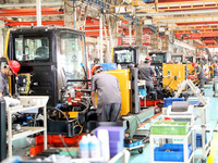 Workers are operating excavators on a production line at LOVOL Co in Qingdao, Shandong province, China, on May 9, 2024. (