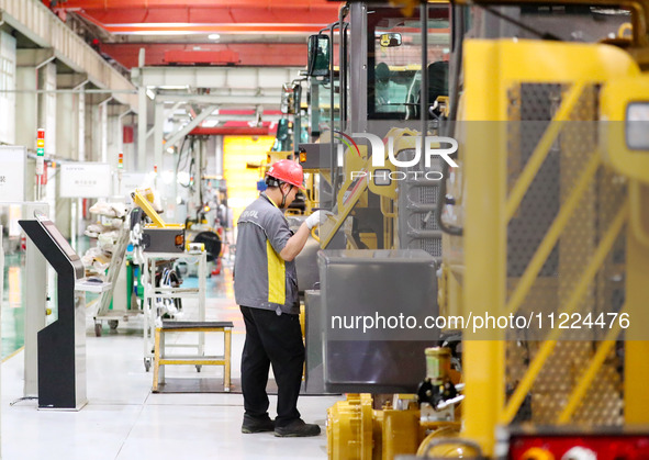 Workers are working on the production line at LOVOL Co in Qingdao, Shandong Province, China, on May 9, 2024. 