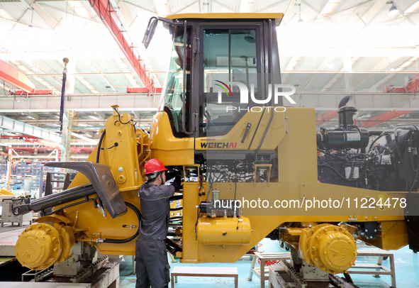 Workers are producing loaders on a production line at LOVOL Co in Qingdao, Shandong Province, China, on May 9, 2024. 