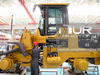 Workers are producing loaders on a production line at LOVOL Co in Qingdao, Shandong Province, China, on May 9, 2024. (