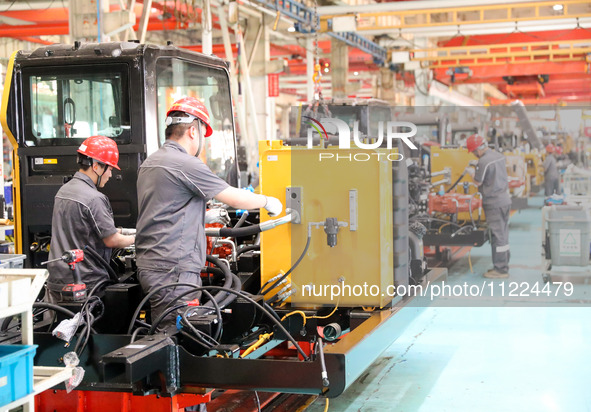 Workers are producing loaders on a production line at LOVOL Co in Qingdao, Shandong Province, China, on May 9, 2024. 