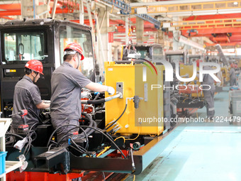 Workers are producing loaders on a production line at LOVOL Co in Qingdao, Shandong Province, China, on May 9, 2024. (