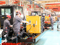 Workers are producing loaders on a production line at LOVOL Co in Qingdao, Shandong Province, China, on May 9, 2024. (