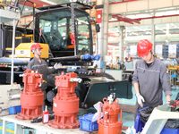 Workers are lifting spare parts at a production line of LOVOL Co in Qingdao, Shandong province, China, on May 9, 2024. (