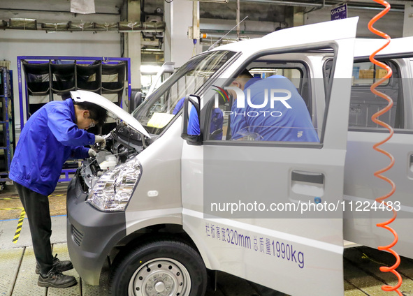 Workers are assembling cars at a vehicle production line at the Qingdao branch of SAIC-GM-Wuling Automobile Co in Qingdao, Shandong Province...