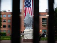 A security guard sits next to the Statue of George Washington behind a tall, "unscaleable" fence following the clearing of the Gaza solidari...