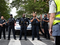 A protest marshal faces a line of DC police as George Washington University students and their supporters rally at the site of their Gaza so...