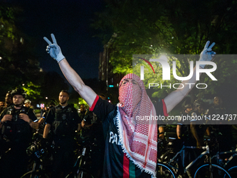 A student at a pro-Palestinian rally chants in front of a line of DC police, Washington, DC, May 9, 2024.  DC Police cleared a Gaza Solidari...