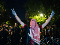 A student at a pro-Palestinian rally chants in front of a line of DC police, Washington, DC, May 9, 2024.  DC Police cleared a Gaza Solidari...