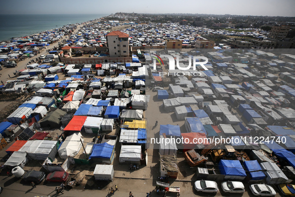 Tents housing internally displaced Palestinians are crowding the beach and the Mediterranean shoreline in Deir el-Balah in the central Gaza...