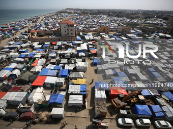 Tents housing internally displaced Palestinians are crowding the beach and the Mediterranean shoreline in Deir el-Balah in the central Gaza...