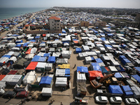 Tents housing internally displaced Palestinians are crowding the beach and the Mediterranean shoreline in Deir el-Balah in the central Gaza...