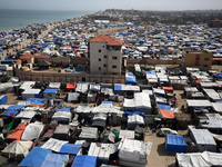 Tents housing internally displaced Palestinians are crowding the beach and the Mediterranean shoreline in Deir el-Balah in the central Gaza...